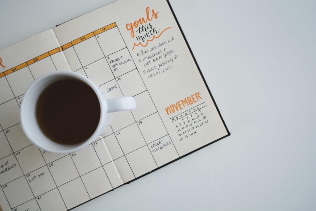xícara de café em cima de calendário editorial para Instagram