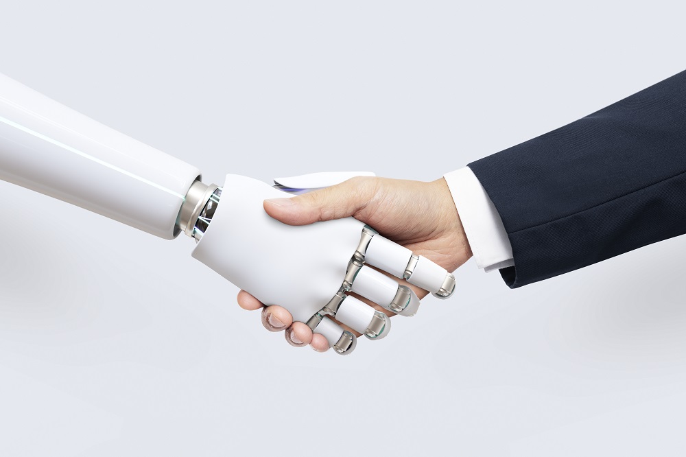 Mão robótica apertando mão humana em cumprimento