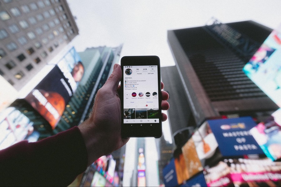 Mão segurando o smartphone logado no aplicativo Instagram