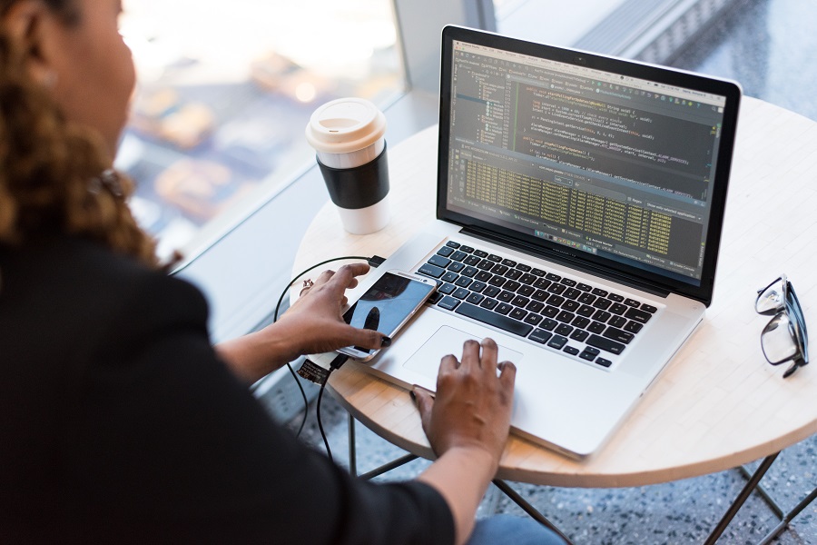 Mulher negra mexe no notebook, que está rodando um software de banco de dados.