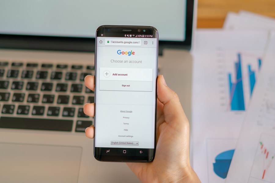 mao segurando celular com google aberto