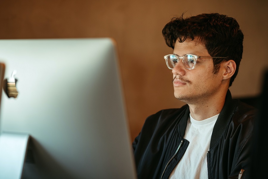 homem de oculos olhando para tela do computador