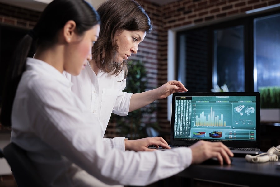duas mulheres analisando dados no computador