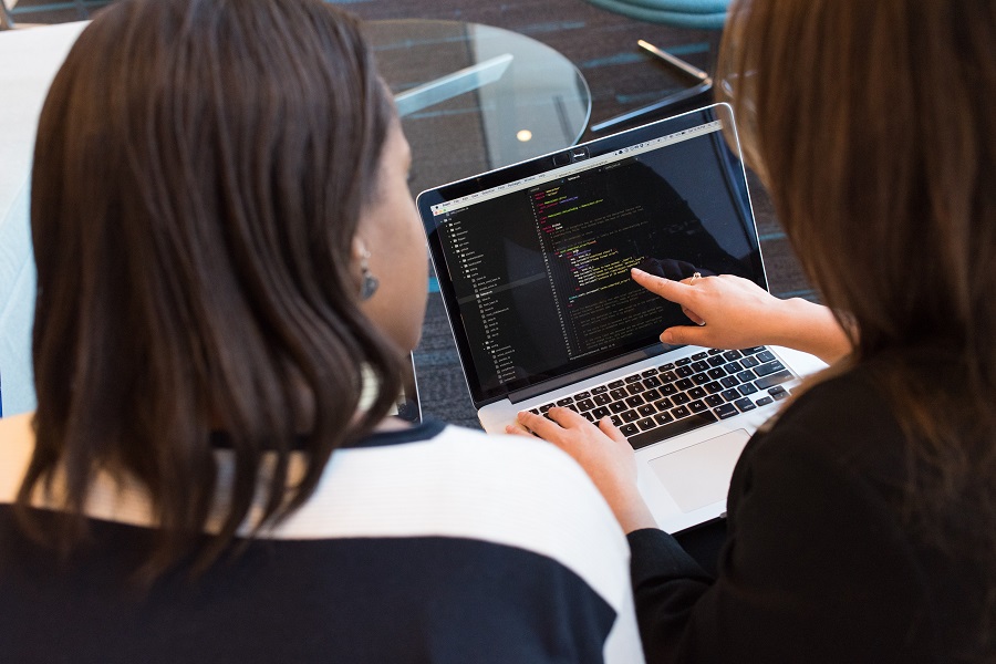 duas mulheres olhando para dados no computador