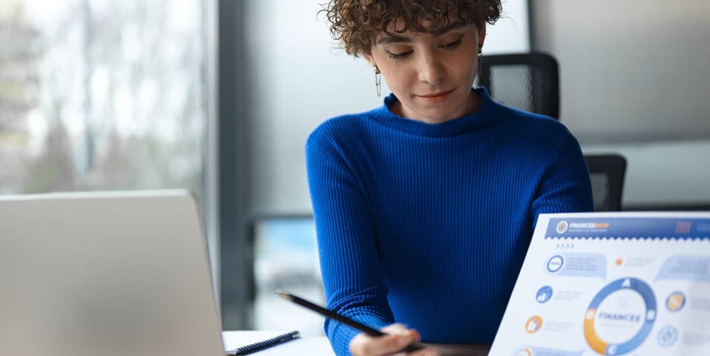 Mulher de blusa azul estudando em um laptop, representando como é o processo para aprender business intelligence.