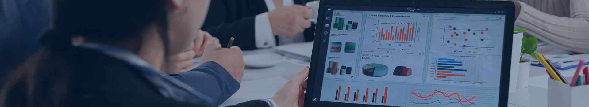 Equipe em reunião analisando dashboards de bi business intelligence em um laptop, com gráficos interativos para análise de dados.