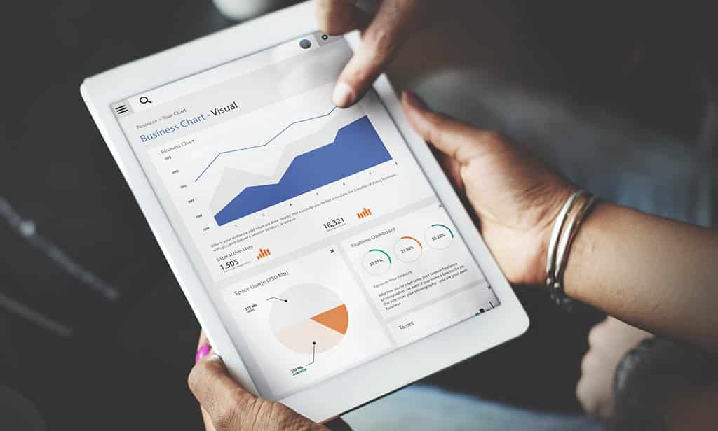 Tablet exibindo gráficos em um dashboard, representando a análise de dados com Power BI e Google Sheets.