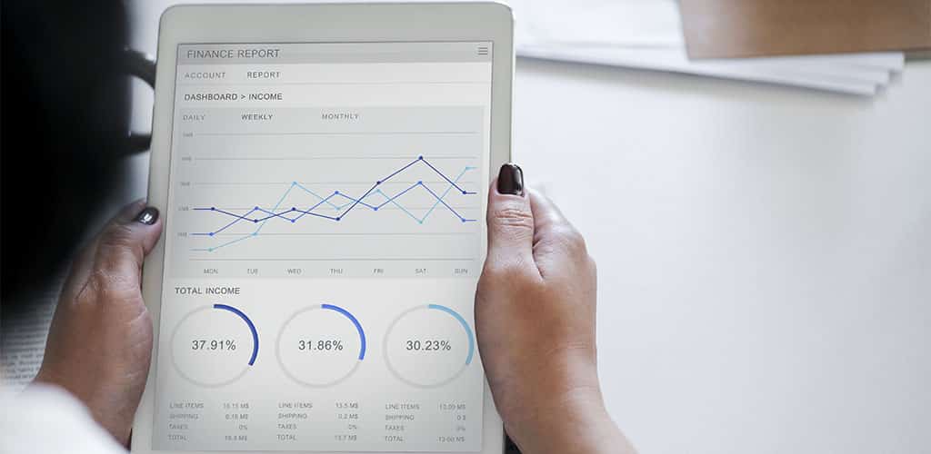 Profissional analisando dashboard personalizado com segmentação de dados Power BI em um tablet com gráficos financeiros interativos.