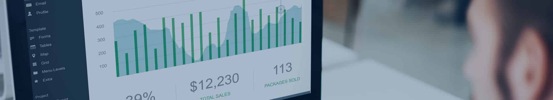 Profissional analisando um dashboard interativo no Power BI em um computador, monitorando vendas e desempenho empresarial.