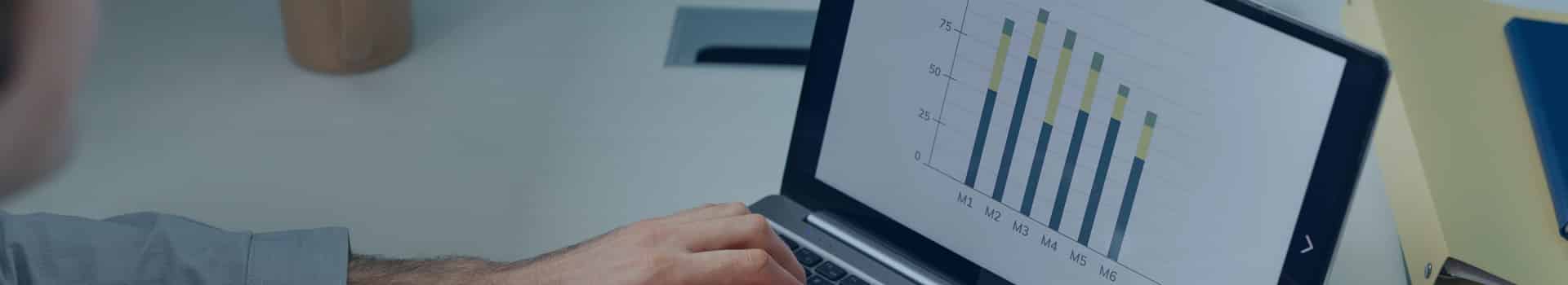 Pessoa analisando gráficos em um laptop, representando uma comparação do Google Data Studio vs Power BI para visualização e análise de dados.