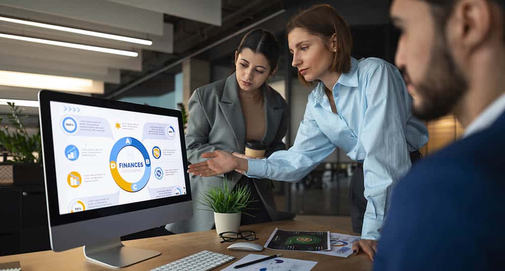 Profissionais analisando gráficos financeiros em equipe, representando o mercado de Business Intelligence e sua aplicação estratégica nas empresas.