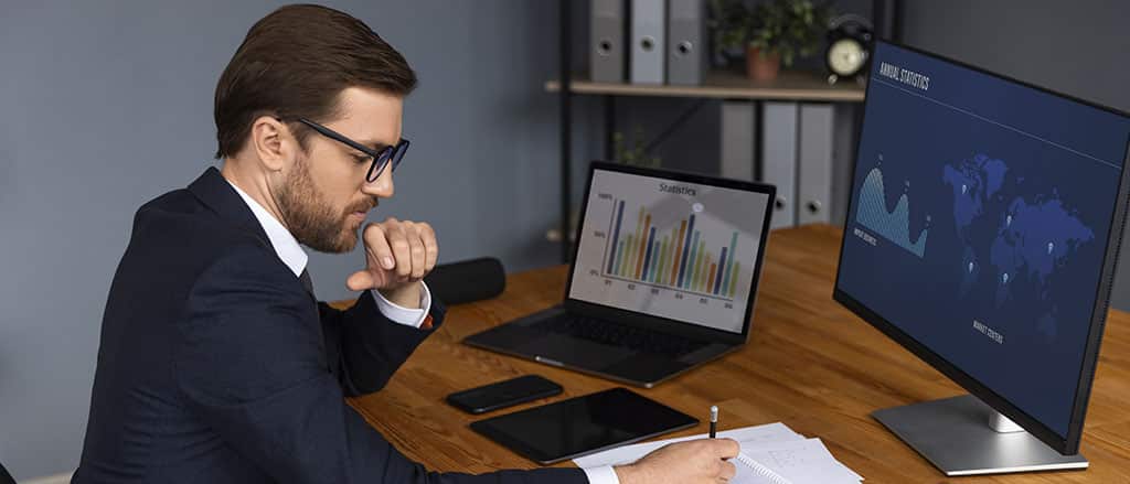 Profissional analisando gráficos e estatísticas em telas, ilustrando o mercado e o salário do analista de Power BI no Brasil.