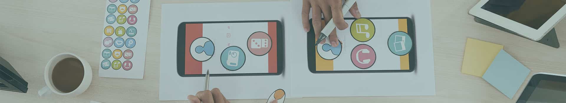 Equipe de desenvolvedores de aplicativos discutindo o design e funcionalidades de um app mobile, com esboços impressos e prototipagem na mesa.