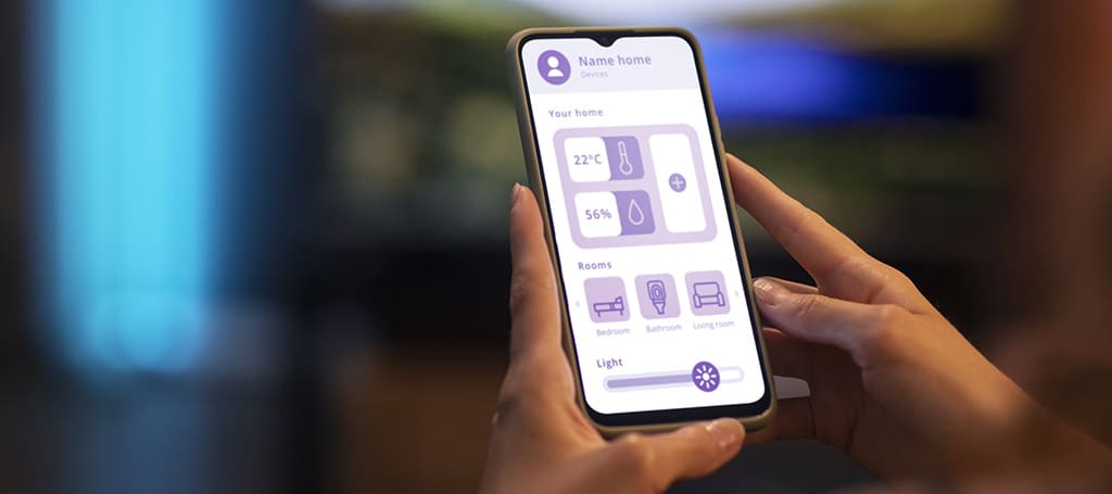 Mão segurando um smartphone com ícones roxos, representando o que é apps, destacando conectividade e tecnologia digital.
