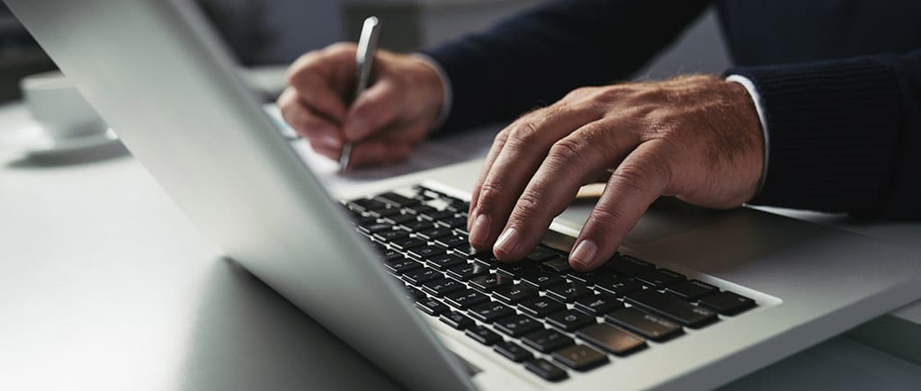 Profissional digitando em laptop, representando o estudo sobre back-end PHP no desenvolvimento de aplicações.