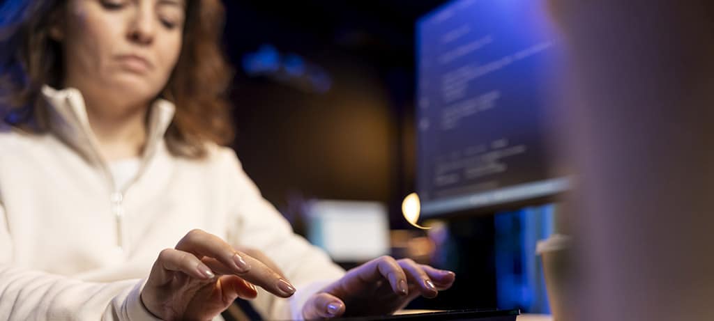 Desenvolvedora escrevendo código em um ambiente tecnológico, representando o trabalho de um desenvolvedor back-end Java.