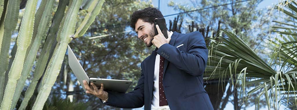 Executivo de tecnologia em grande centro urbano consultando em seu notebook quanto ganha um desenvolvedor mobile.