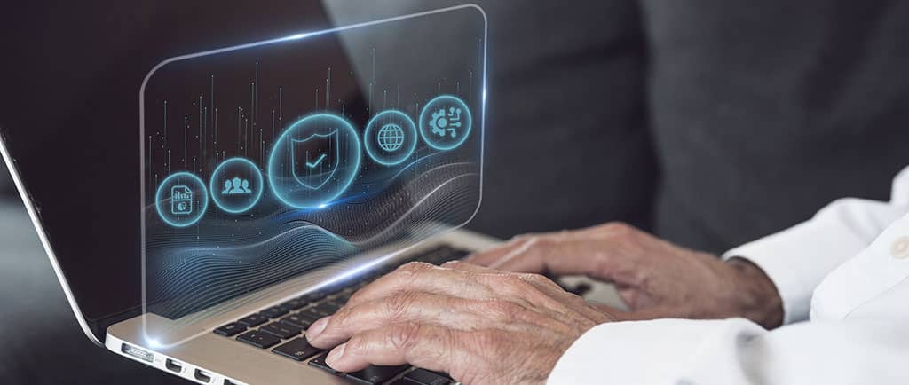 Usuário escolhendo o melhor software de monitorar rede em um laptop para acompanhar a segurança e o desempenho da conexão.