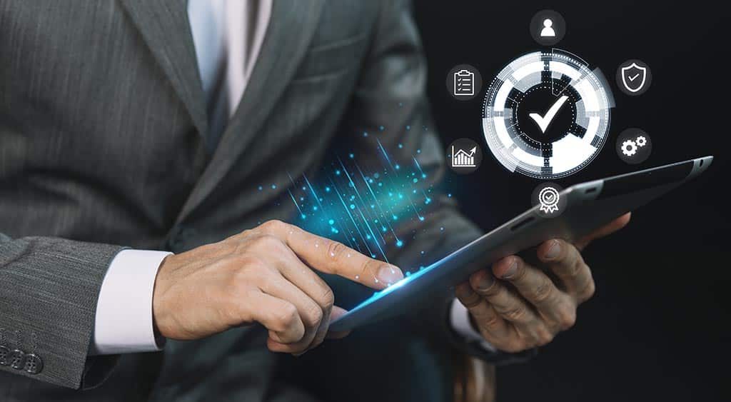 Profissional utilizando tablet com interface digital representando padrões de arquitetura de software, qualidade e eficiência em processos tecnológicos.
