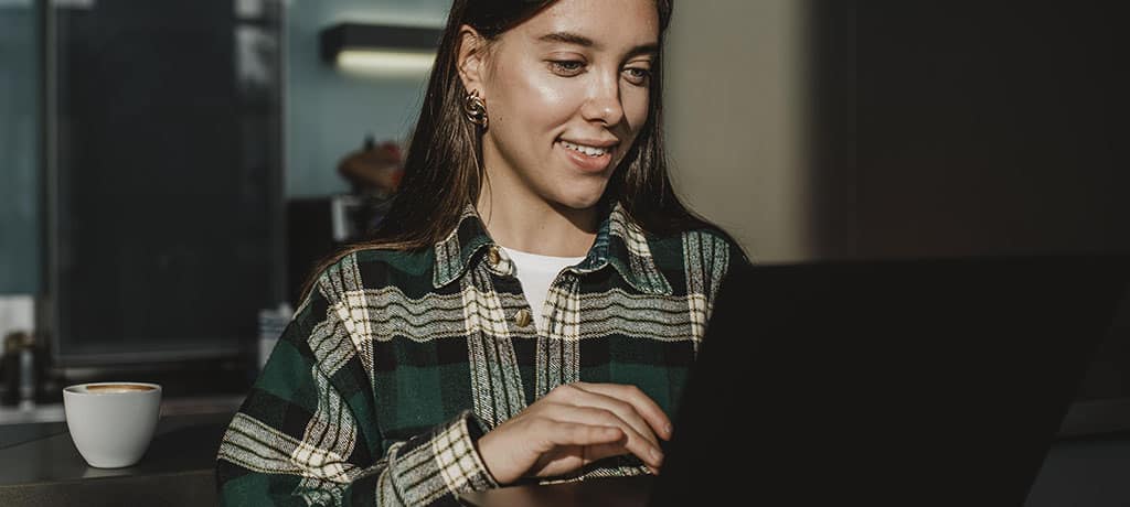 Profissional utilizando um laptop para monitoramento de dados com os principais recursos do Coralogix, destacando a facilidade de uso da plataforma para análise de logs.