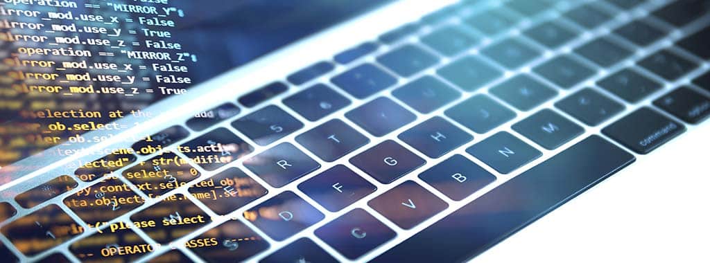 Teclado de laptop com código refletido na tela, representando um framework backend.