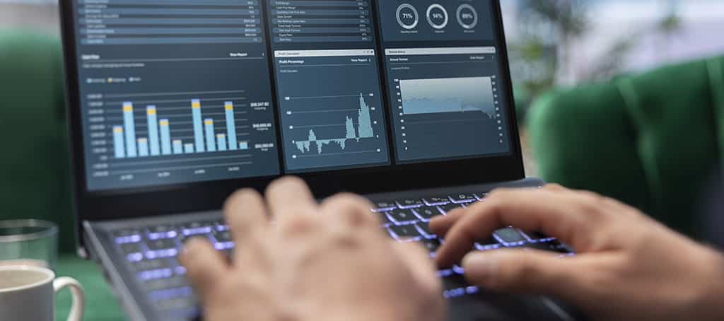 Profissional analisando dashboards de monitoramento no laptop, representando a eficiência da gestão de redes com Aruba AirWave.