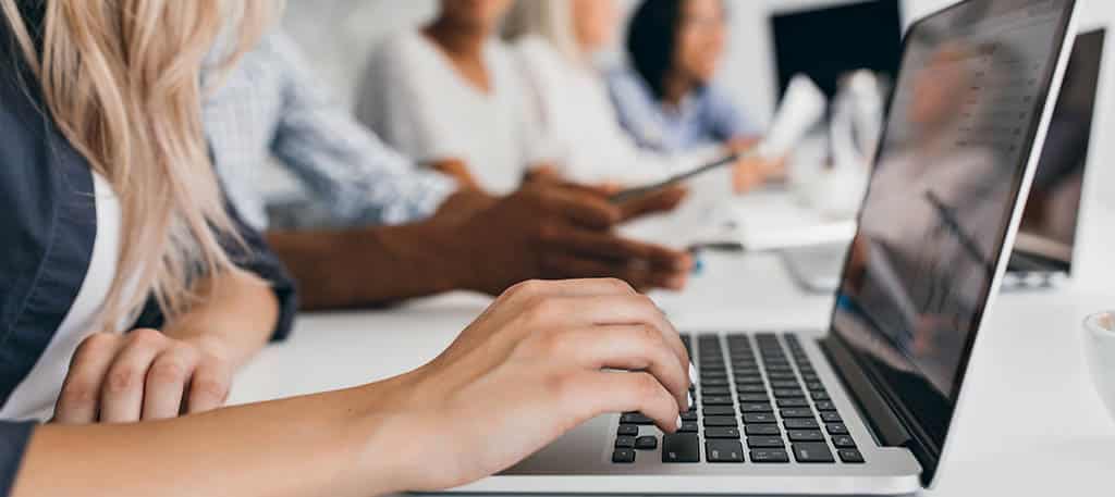 Estudante participando de um curso back-end gratuito online, com fones de ouvido e laptop.