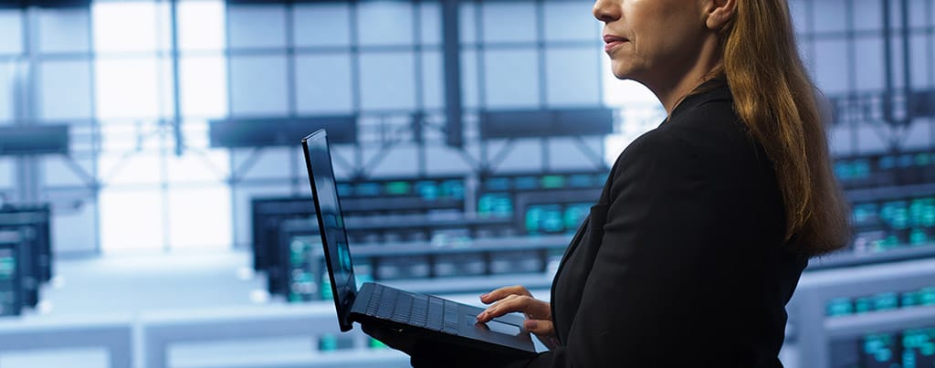 Especialista em TI monitorando servidores virtuais em um datacenter moderno.