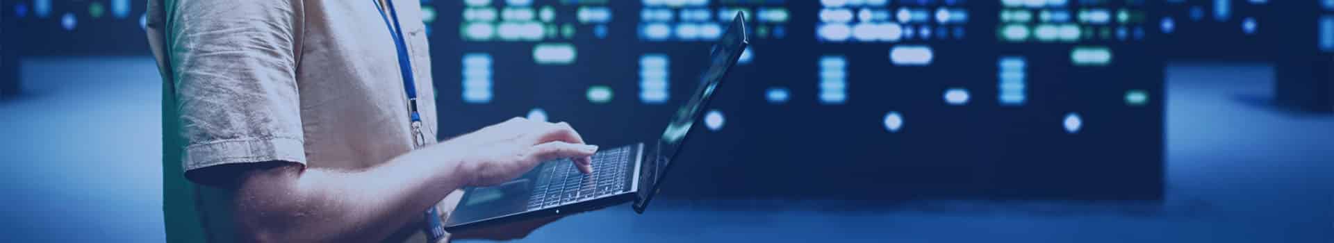 Profissional de TI analisando servidores virtuais em um datacenter moderno.