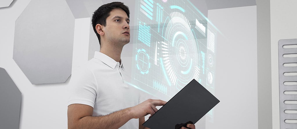 Homem interagindo com uma interface holográfica, representando a tecnologia de um computador virtual e de ambientes digitais imersivos.