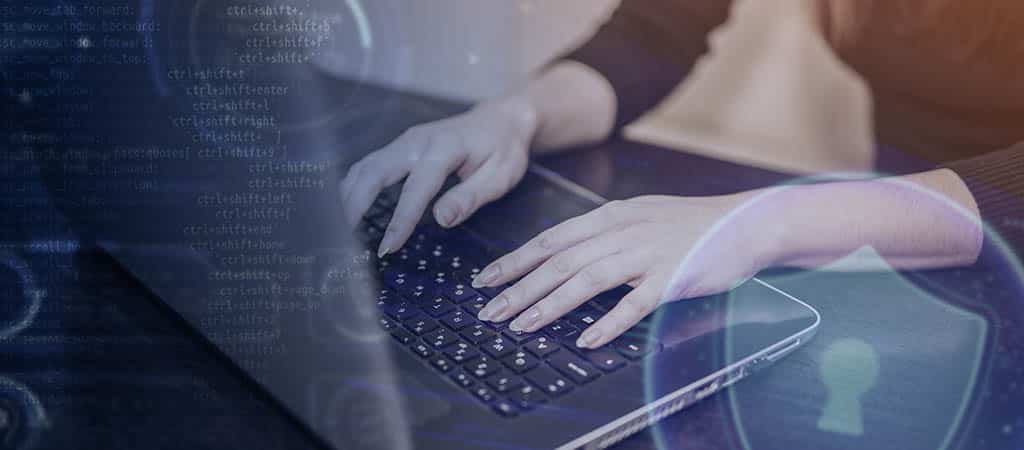 Profissional mulher digitando em laptop com elementos gráficos de segurança e código, representando o trabalho com diferentes requisitos arquiteturais em arquitetura de software.