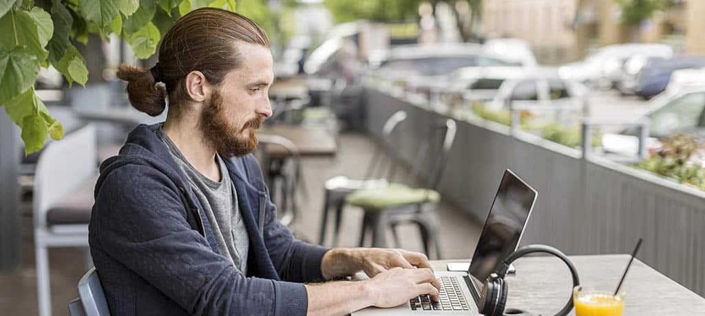 Profissional programando ao ar livre e desfrutando de seu salário em back-end, representando a flexibilidade e oportunidades da carreira em tecnologia.