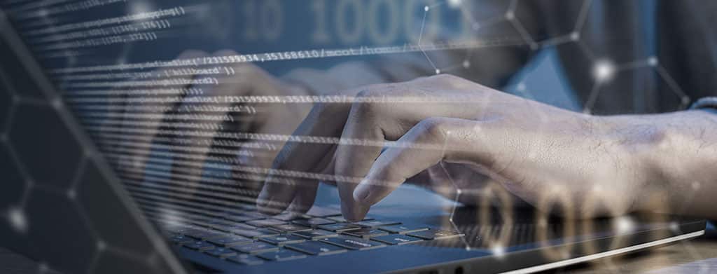 Profissional digitando em laptop com códigos e gráficos, simbolizando o desenvolvimento e gerenciamento de NFV.