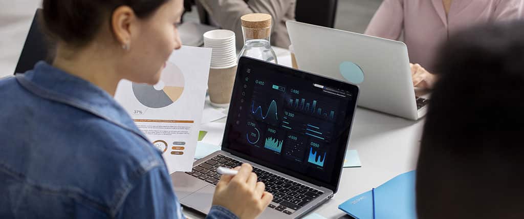Profissional analisando métricas de rede em um dashboard interativo, representando o uso do Paessler PRTG para monitoramento eficiente de sistemas.