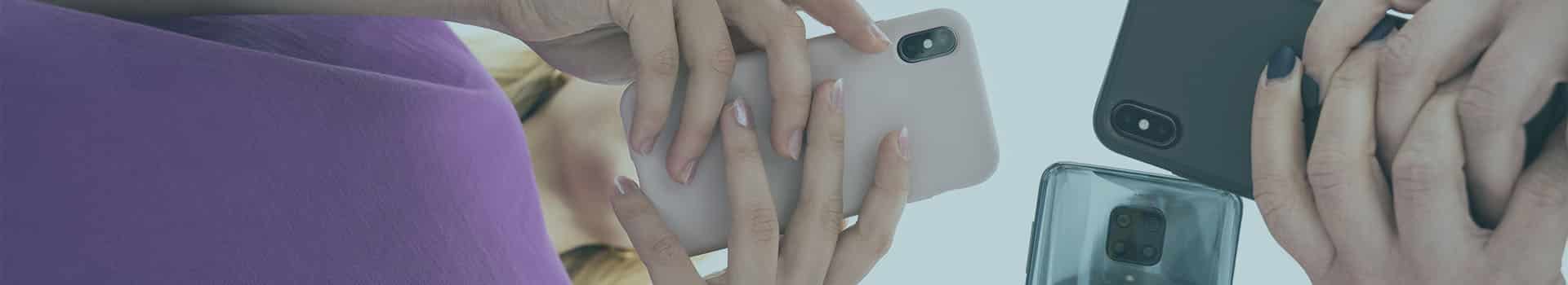 Diferentes pessoas segurando celulares, representando o desenvolvimento mobile multiplataforma.