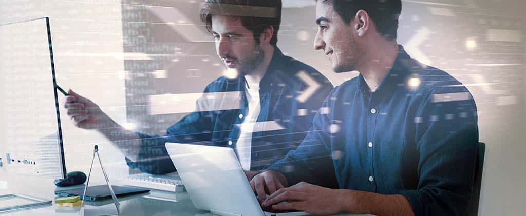 Dois profissionais de TI analisando dados e monitorando redes com o Zabbix em um ambiente de trabalho tecnológico.