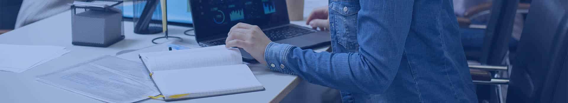 Profissional de TI monitorando métricas no Zabbix em um ambiente de trabalho colaborativo.
