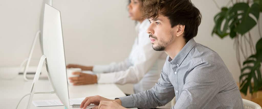 Profissional de TI analisando dados em um computador, utilizando o SolarWinds para monitoramento e gerenciamento eficiente da infraestrutura de redes.