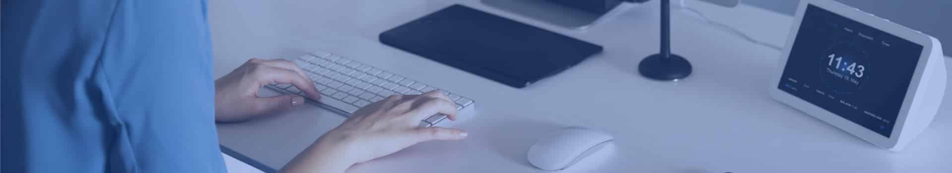 Mulher digitando em um teclado enquanto usa um computador, possivelmente configurando opções para ativar virtualização Windows 7.