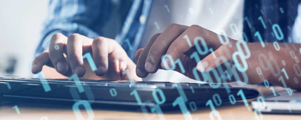 Usuário digitando em laptop enquanto utiliza o Lansweeper para análise e monitoramento de rede.