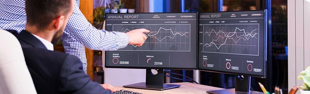 Profissionais de TI analisando gráficos de monitoramento em tempo real, representando o uso do Spiceworks na gestão de redes.
