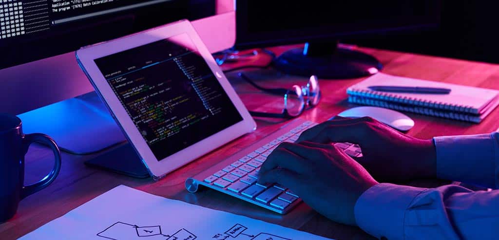 Profissional desenvolvendo código com um diagrama ao lado, representando conceitos de arquitetura de software e engenharia de software.