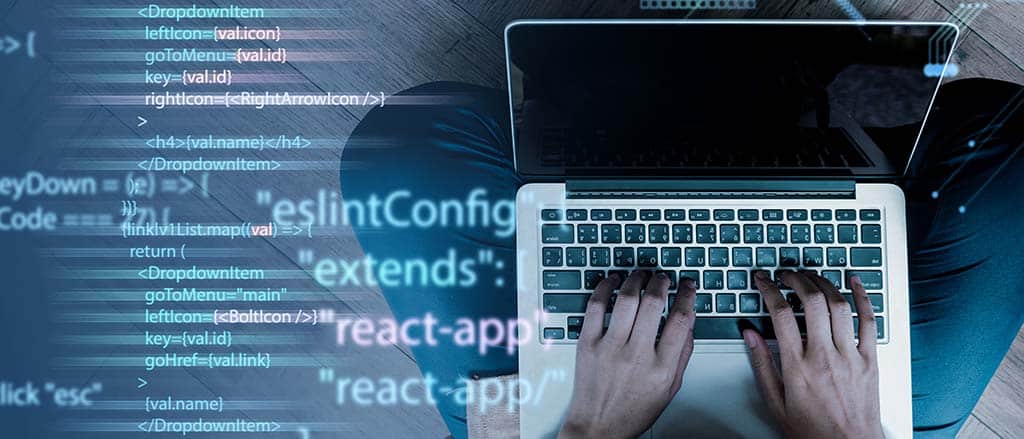 Mãos digitando em um laptop com código na tela, representando a relação entre arquitetura de software e engenharia de software no desenvolvimento de sistemas.
